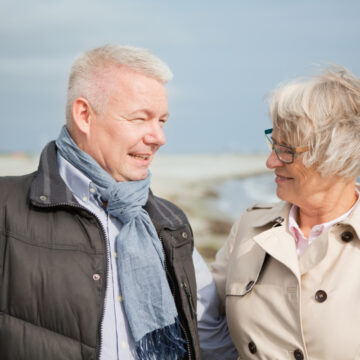 Mand og kvinde ved vindblæst strand