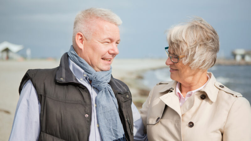 Mand og kvinde ved vindblæst strand