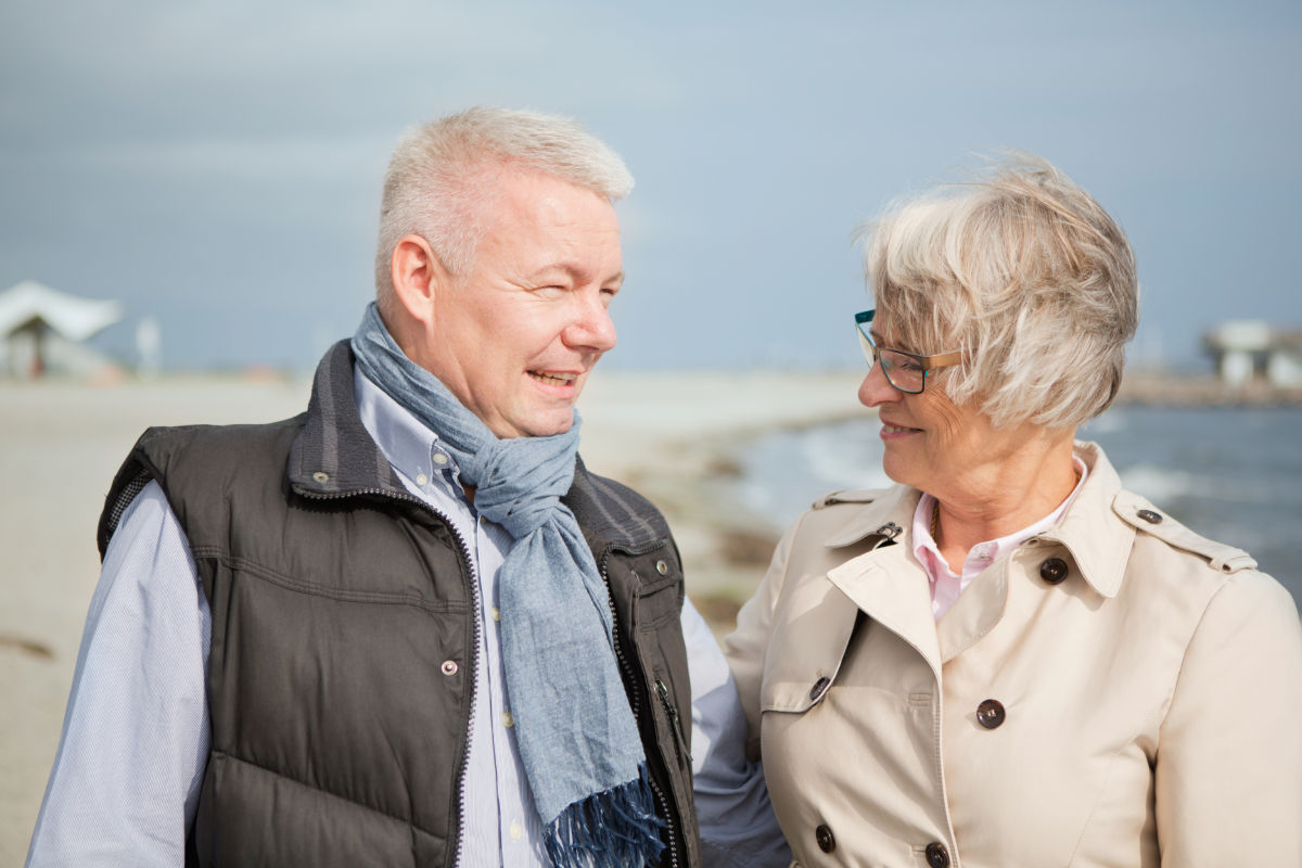 Mand og kvinde ved vindblæst strand