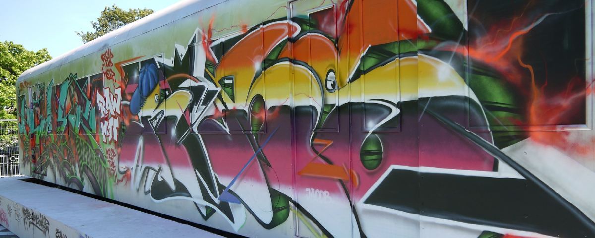 Farverigt graffiti-maleri med abstrakte former på en væg.