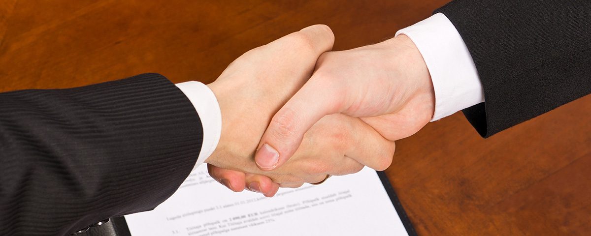 3. To personer, der giver hinanden hånd over et dokument.