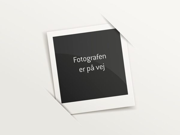 En polaroidramme med teksten "Fotografen er på vej" på en sort baggrund.