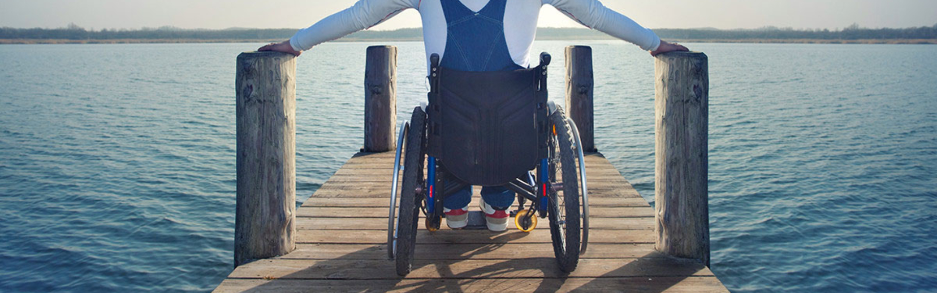 Mand i kørestol på bro ved vandet
